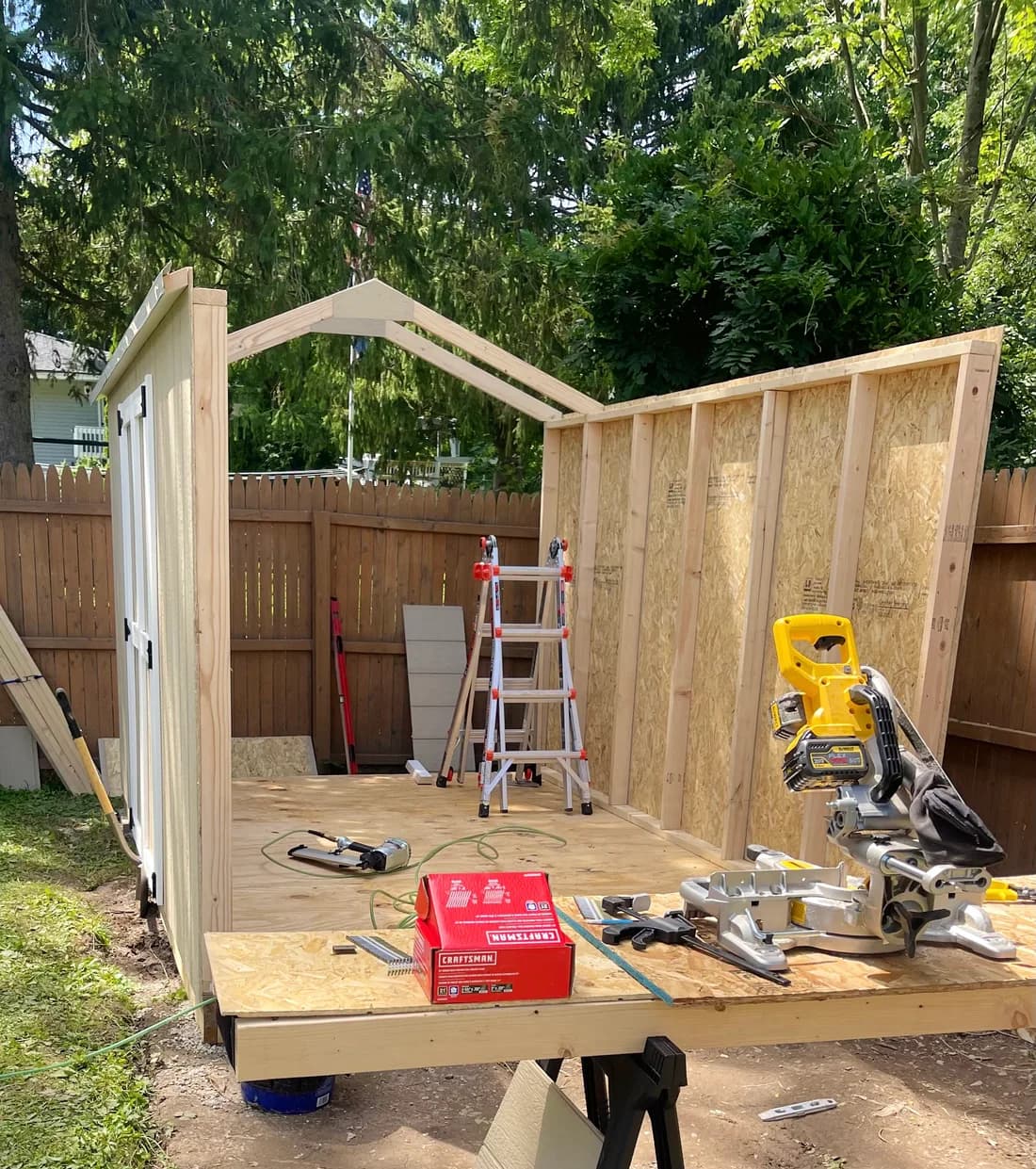 Shed walls and floor being built on-site in a fenced backyard